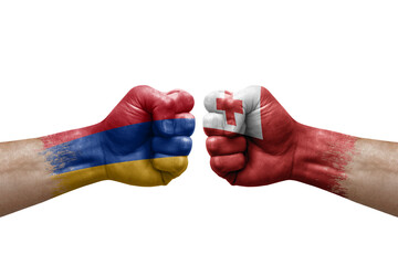 Fototapeta premium Two hands punch to each others on white background. Country flags painted fists, conflict crisis concept between armenia and tonga