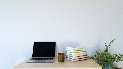 机上の本とノートパソコン