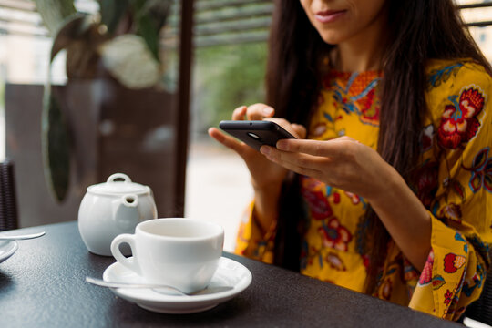 Woman using a smartphone during breakfast