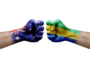 Two hands punch to each others on white background. Country flags painted fists, conflict crisis concept between australia and gabon