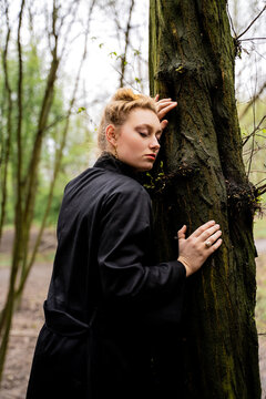 Blonde Woman Leaning Against Tree