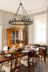 A table set for dinner in a rustic modern farmhouse with sunlight coming through a window.