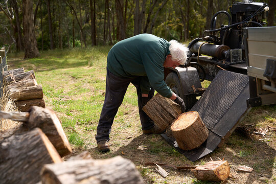 Senior man working on log splitter machine