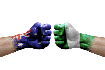 Two hands punch to each others on white background. Country flags painted fists, conflict crisis concept between australia and nigeria