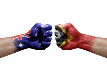 Two hands punch to each others on white background. Country flags painted fists, conflict crisis concept between australia and timor leste