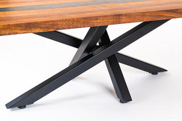 Close up of a Curly Bastogne Walnut wooden coffee table with black epoxy resin and metal legs....