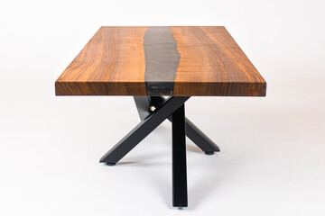 Curly Bastogne Walnut wooden coffee table with black epoxy resin and metal legs. White studio backdrop.