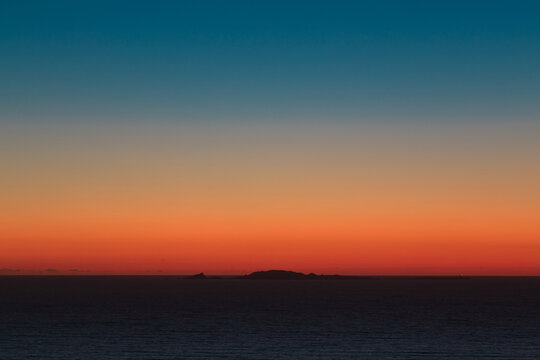 Colorful sunset with a mountain on the bottom 