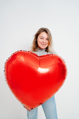 an blonde woman with a large red heart-shaped balloon. valentine's day