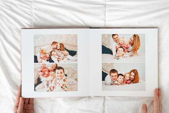 a hands with a book with photos of big family at home on a white background.