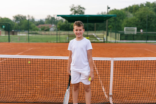 Young tennis player standing on a tennis court portrait