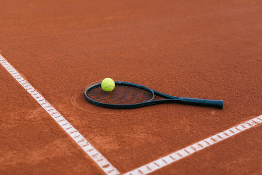 Tennis racquet on a court with tennis ball