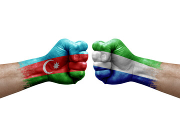 Two hands punch to each others on white background. Country flags painted fists, conflict crisis concept between azerbaijan and sierra leone