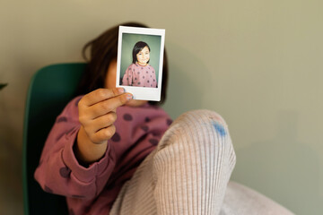 Little girl showing her polaroid pic