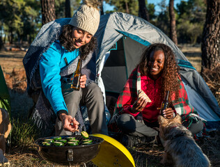 Smiling diverse hikers grilling vegetables