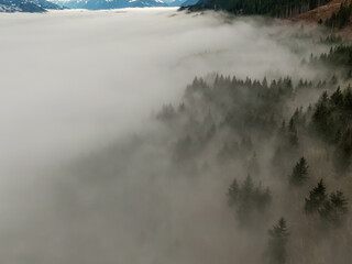 Aerial View of Canadian Mountain Landscape covered in fog over Harrison Lake. Winter Season. British Columbia, Canada. Nature Background