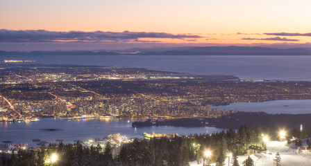 View of Top of Grouse Mountain Ski Resort with the City in the background. North Vancouver, British Columbia, Canada. Sunset Sky