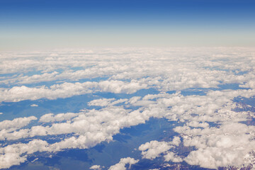 Above Fluffy Clouds and Blue Sky Viewed From Plane