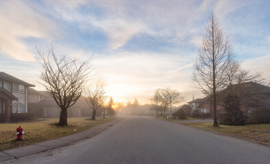 Fototapeta na wymiar Fraser Heights, Surrey, Greater Vancouver, BC, Canada. Beautiful Street view in the Residential Neighborhood during a colorful Winter Season. Dramatic Sunrise Sky.
