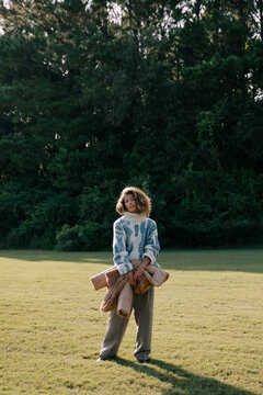 Pulled back portrait of young woman in field.