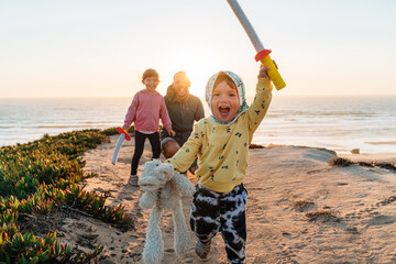 Obraz premium Happy family playing outdoors at sunset 