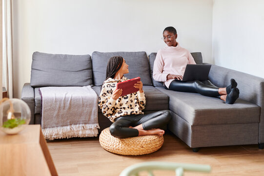 Mom and daughter using different devices at home