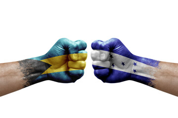 Two hands punch to each others on white background. Country flags painted fists, conflict crisis concept between bahamas and honduras