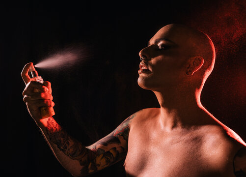 Crop gay bald man with naked torso and applying makeup fixer