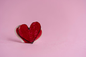corazón rojo de papel sobre fondo de papel color rosa con espacio para texto