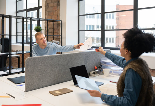 People Sharing Documents In Office