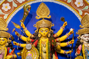 Goddess Durga idol at decorated Durga Puja pandal, shot at colored light, at Kolkata, West Bengal, India. Durga Puja is biggest religious festival of Hinduism and is now celebrated worldwide.