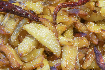 Close up image of fried potato pieces with fried red chilly - a fast food dish . Popular amongst Indians as a tasty snacks.