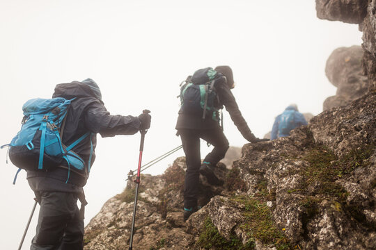 Group of senior hikers climbing rocks