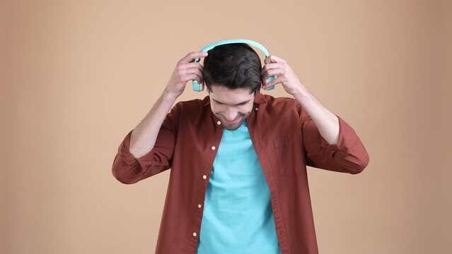 Excited guy listen headset rock melody dance isolated patel color background