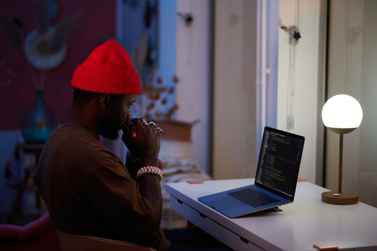 pensive black man working on his laptop