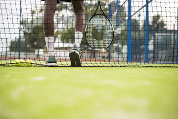 Anonymous man with tennis racket waiting near the net