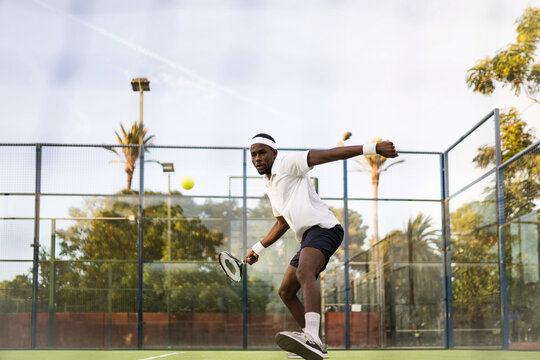 Black man playing with a racket in a tennis match