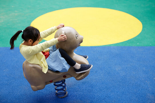 Asian girl, happy to play with animal spring chair



