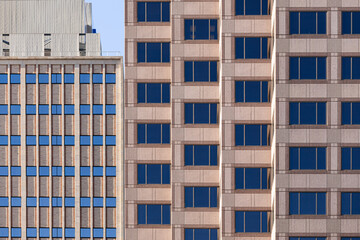 the front of 2 buildings with dark windows 