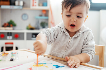 Boy painting with stick.
