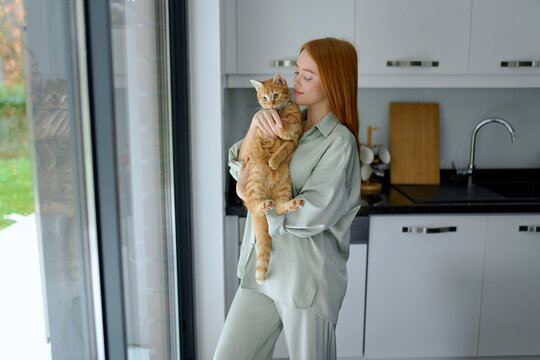 a woman hugs her pet at home