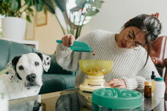 Woman measuring dog food with scale