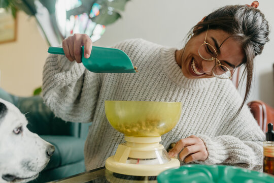 Smiling woman measuring dog food