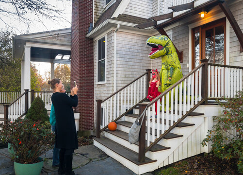 Mother taking photo of kids in Halloween Costumes 
