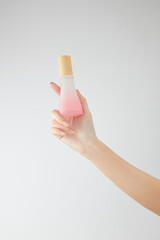 Hand model holding a cosmetic jar with a white background for cosmetic advertising