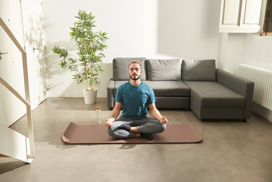 Young man at home, doing yoga