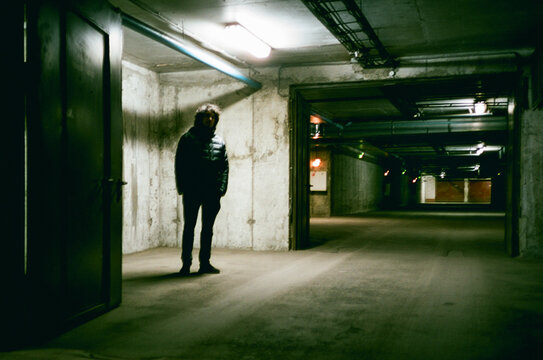 Man waiting inside a parking lot at night
