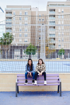 Teen girls sitting in an urban park