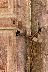 Old wooden door with a rusty chain and lock