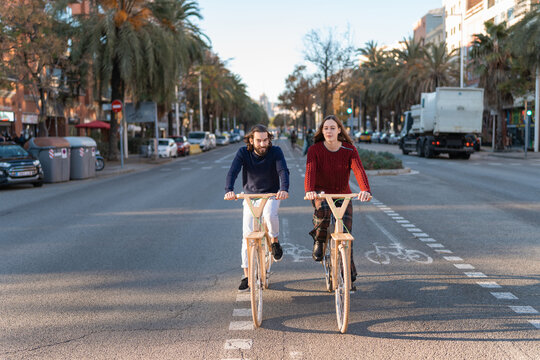 Content young couple riding eco bicycles on road